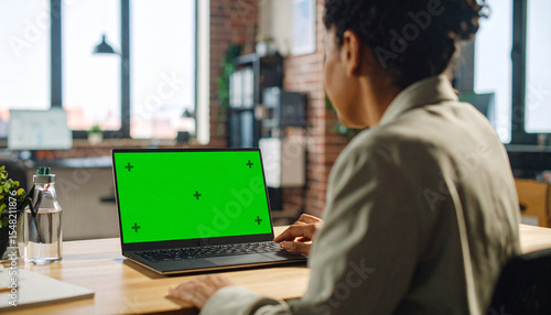 Creative Home Office Scene with Woman Using Laptop, Green Screen Ready for Replacement

