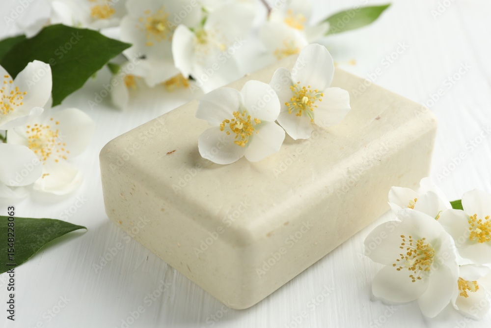 Soap bar and jasmine flowers on white wooden table, closeup Soap bar and jasmine flowers on white wooden table, closeup