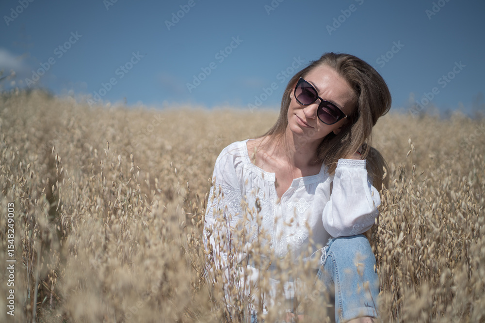 Caucasian 30s Woman Sitting in Wheat Field Wearing Sunglasses on a Sunny Day Caucasian 30s Woman Sitting in Wheat Field Wearing Sunglasses on a Sunny Day