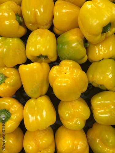 A colorful close-up of freshly harvested yellow bell peppers, beautifully arranged and glowing with natural shine. This image captures the freshness, texture, and vibrancy of the vegetables.