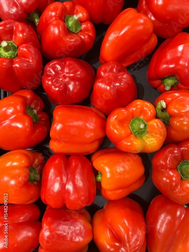 A colorful close-up of freshly harvested red bell peppers, beautifully arranged and glowing with natural shine. This image captures the freshness, texture, and vibrancy of the vegetables.