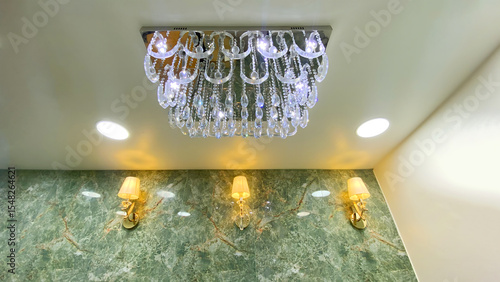Elegant Wall Sconce Lamp with White Lampshade and Crystal Drop on Luxury Green Marble Wall in Modern Interior