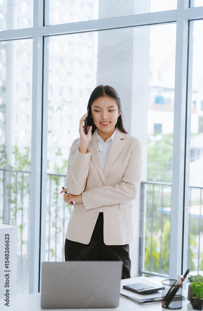 Fototapeta premium Confident Asian Businesswoman on Mobile Phone