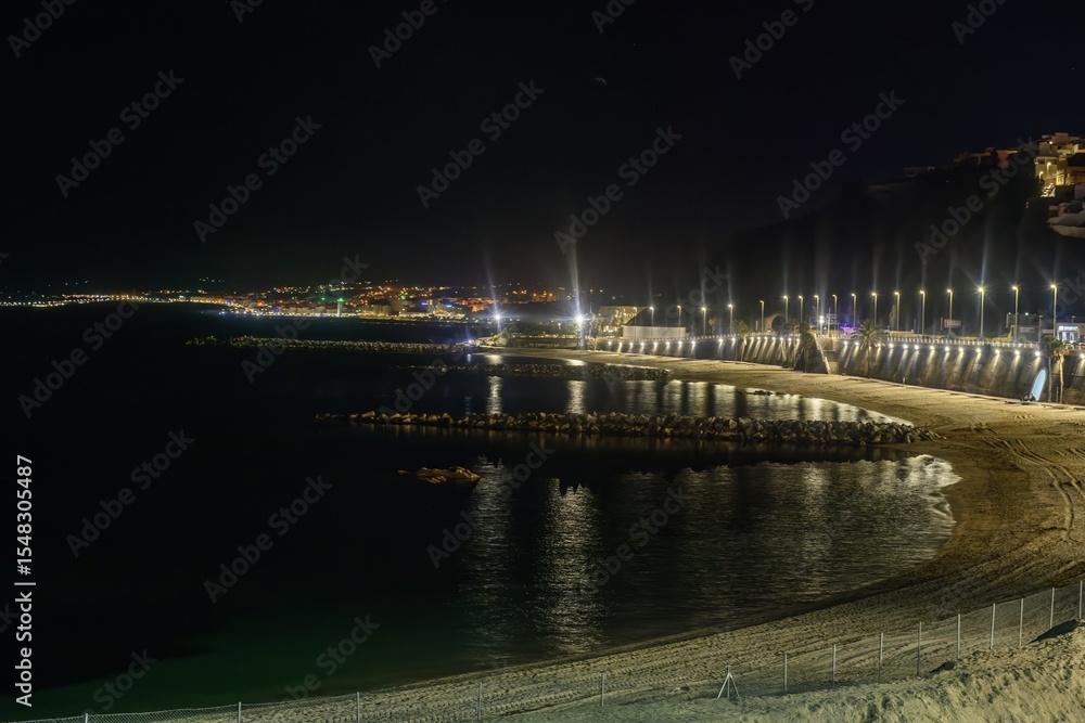 Fototapeta premium Coastal night view of Ceuta illuminated by streetlights
