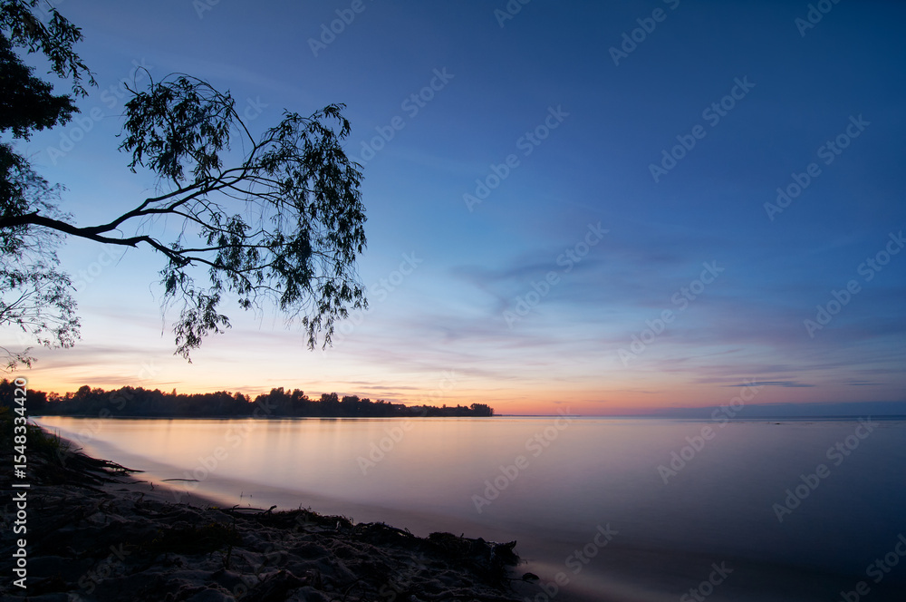 Tranquil Sunset over Calm Lake with Silhouetted Tree Branch Tranquil Sunset over Calm Lake with Silhouetted Tree Branch