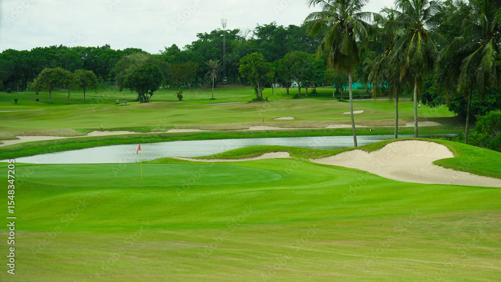 Fototapeta premium Golf Course with Sand Bunkers and Palm Trees in Tropical Setting.