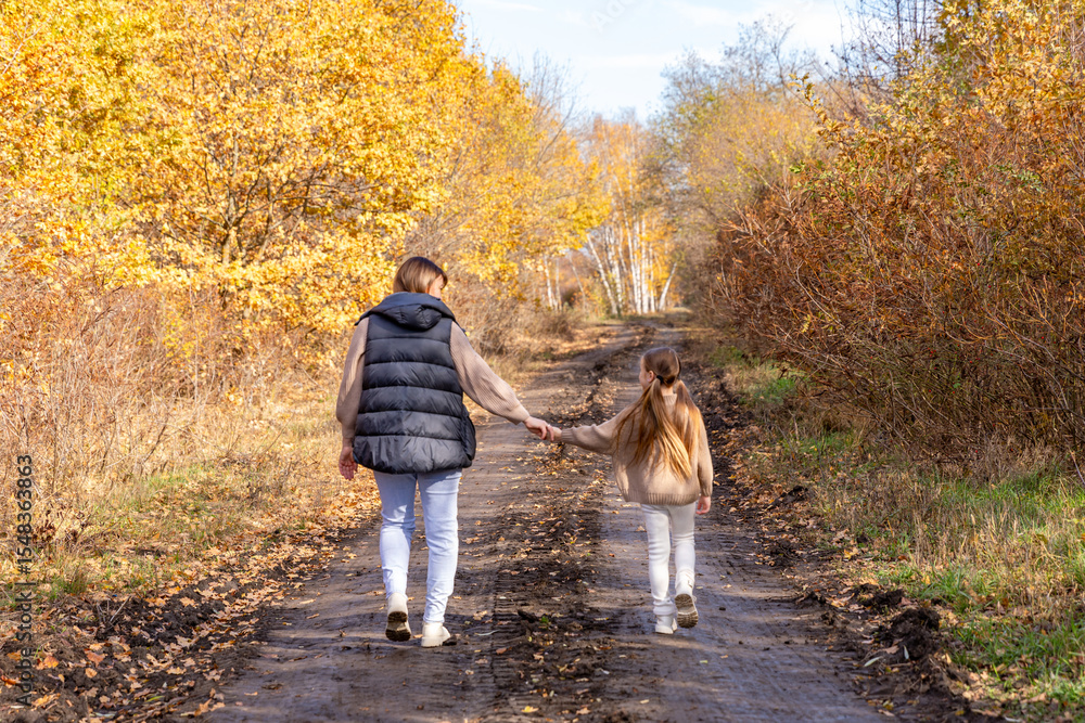 Rear view mother walking and holding hands with daughter for bonding, outdoor adventure or journey in nature. Mom strolling with child, kid or little girl on sidewalk in autumn season at park Rear view mother walking and holding hands with daughter for bonding, outdoor adventure or journey in nature. Mom strolling with child, kid or little girl on sidewalk in autumn season at park