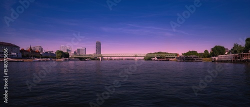 View from the middle of the Danube to the old bridge and the district with the tallest skyscraper in Bratislava, Slovakia