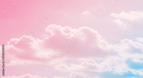 A view of soft pastel colored sky with fluffy clouds in shades of pink and light blue gradient hue