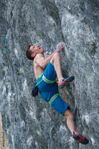 Obraz na plátně CLOSE UP, LOW ANGLE VIEW: Focused athlete climbing a challenging rocky cliff