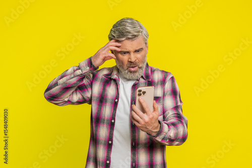 Fotografie Upset sad Caucasian mature man use smartphone typing browsing, play game, loses, surprised by sudden lottery results bad fortune loss fail unlucky news
