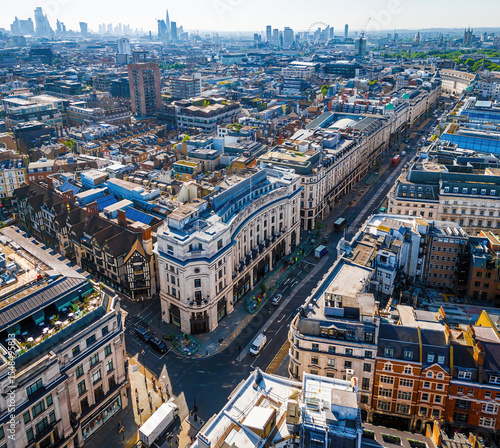 Photography Aerial view of Regent Street in London with its sweeping curve, elegant architecture, red buses, and busy city streets on a clear day