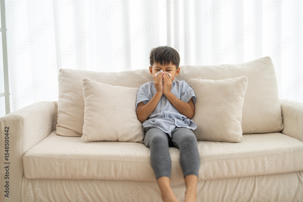 Young asian boy sneezing or blowing his nose and mouth with tissue, cold allergies or illness, health, virus and flu season, RSV, Influenza, childcare and hygiene practices, especially for children Young asian boy sneezing or blowing his nose and mouth with tissue, cold allergies or illness, health, virus and flu season, RSV, Influenza, childcare and hygiene practices, especially for children