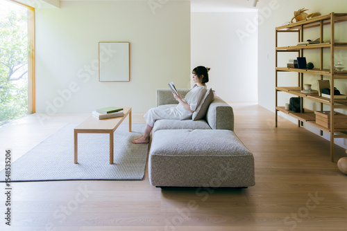 リビングで本を読む女性