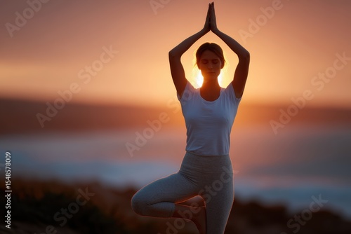 Woman doing yoga on beach during sunrise