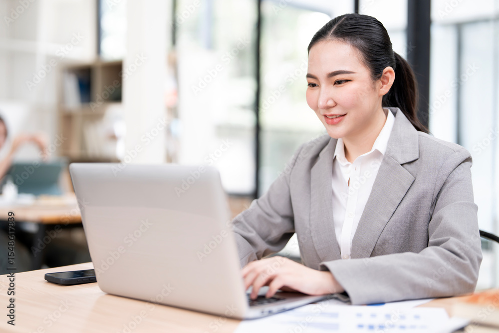 portrait of an attractive young businesswoman working on her laptop while sitting in the office. portrait of an attractive young businesswoman working on her laptop while sitting in the office.