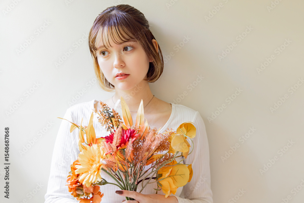 Fototapeta premium 花を持った若い女性のポートレート