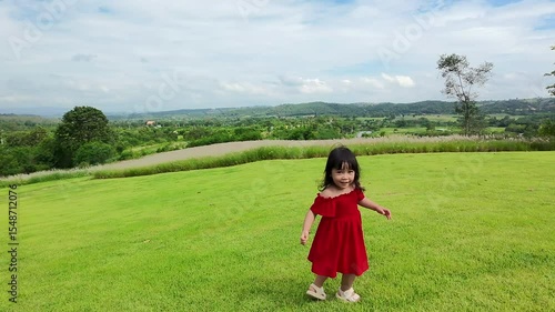 Wallpaper Mural happy toddle girl in red dress running on a grass field Torontodigital.ca
