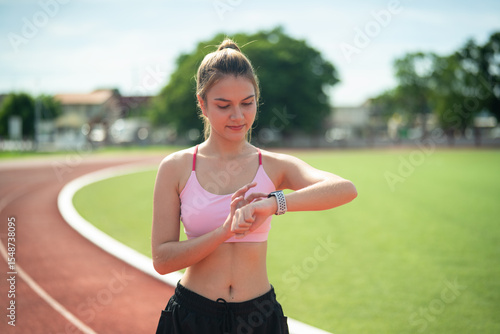Sporty woman reviews her fitness data on track