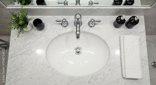 Overhead shot of a bathroom sink with marble countertop and decorative items in a well lit space