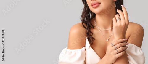 Cuadro en lienzo Young woman in silver jewelry on grey background, closeup
