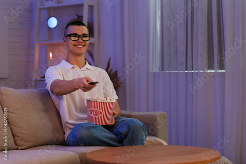 Young man with popcorn watc...