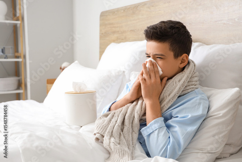 Sick little boy with tissue...