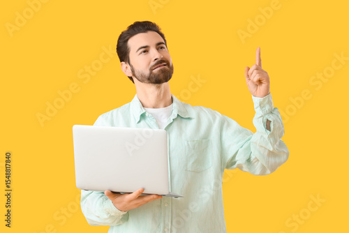 Handsome man with laptop po...