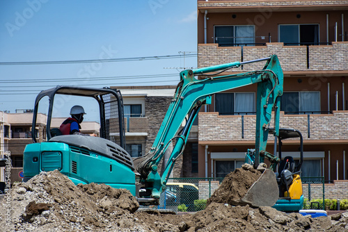 小型ショベルカーで住宅地の造成作業をする作業員