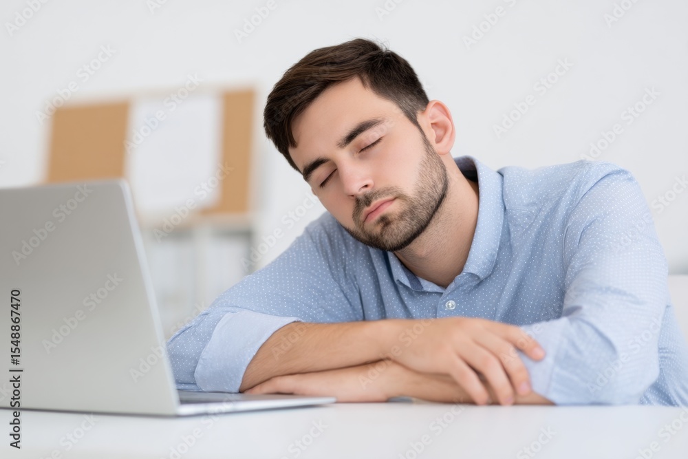 Young caucasian male adult sleeping at desk with laptop in office environment Young caucasian male adult sleeping at desk with laptop in office environment
