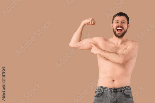 Man showing muscles on beig...
