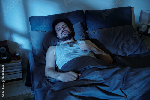 Cuadro en lienzo Caucasian man lying in bed with eyes closed, appearing troubled or restless, han