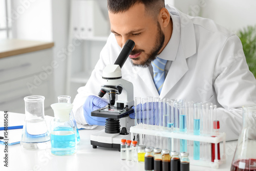 Male scientist looking thro...