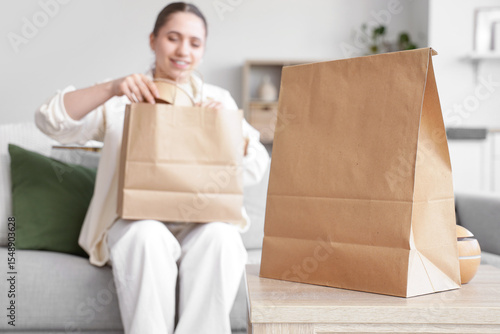 Young woman unpacking brown...