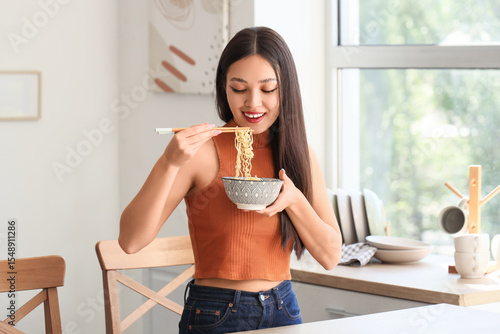 Young Asian woman eating ta...