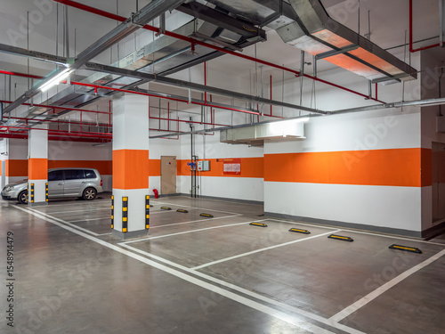 Foto Modern Parking Garage Featuring Bright Orange Accents and Open Spaces