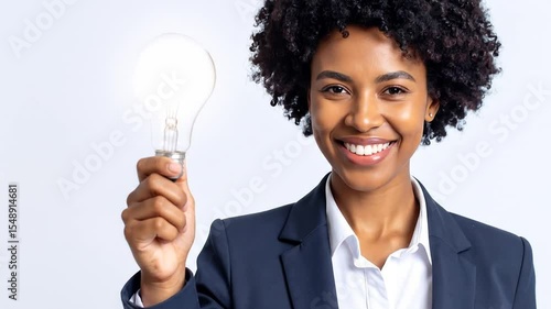 Wallpaper Mural A woman in a suit holds an illuminated light bulb, showcasing a happy expression Torontodigital.ca