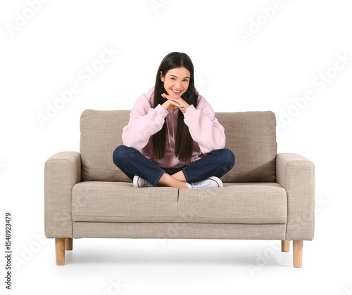 Young woman sitting on grey...