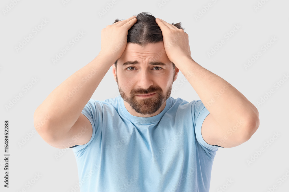 Sad man on light background. Hair loss problem Sad man on light background. Hair loss problem