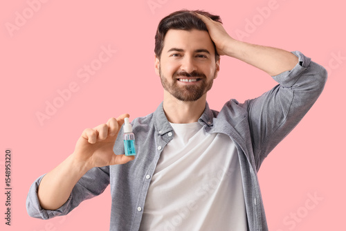 Man holding serum for hair ...