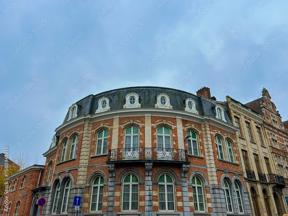 Obraz premium Victorian architecture corner building in Leuven with round roof and white windows