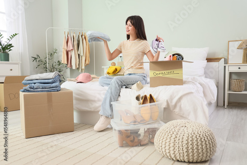 Young woman packing clothes...