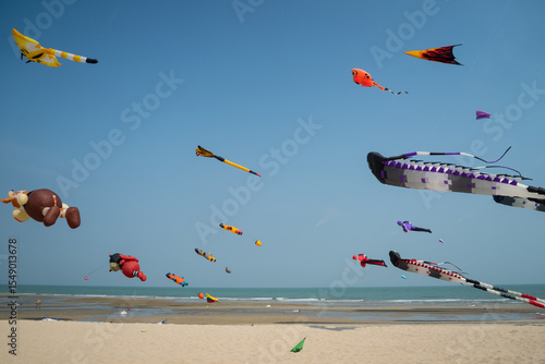 Flying kite festival with Octopus, jellyfish, shark fish and shaped animal. Various colorful kites flying in the blue sky on the public beach. Free public event featuring local of Thailand.