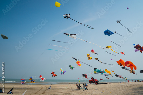 Flying kite festival with Octopus, jellyfish, shark fish and shaped animal. Various colorful kites flying in the blue sky on the public beach. Free public event featuring local of Thailand.