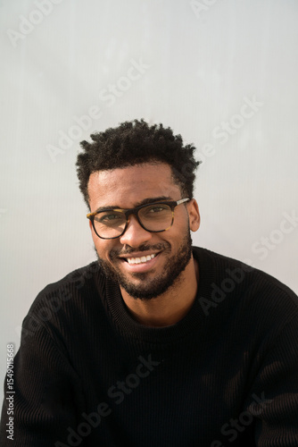 Smiling man in black sitting outdoors