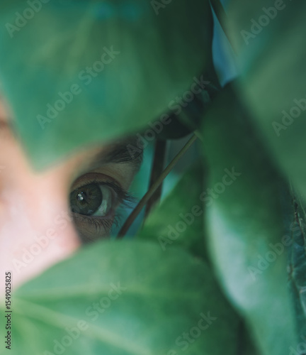 Female eye poking through the leaves