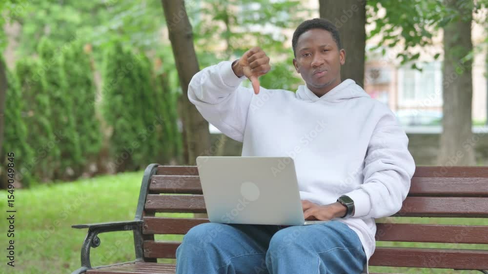 Thumbs Down by Young African Man with Laptop Outdoor Thumbs Down by Young African Man with Laptop Outdoor
