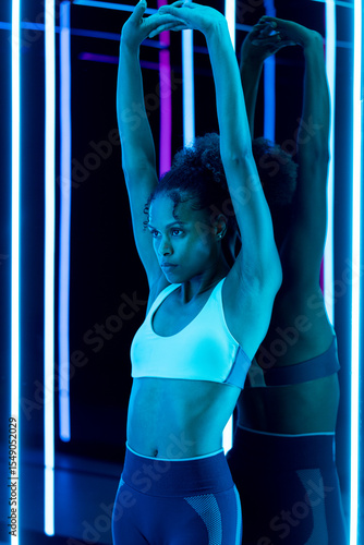 Woman stretching under neon lights