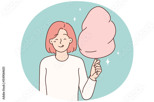 Cheerful girl with cotton candy in hands licks lips in anticipation taste of street dessert