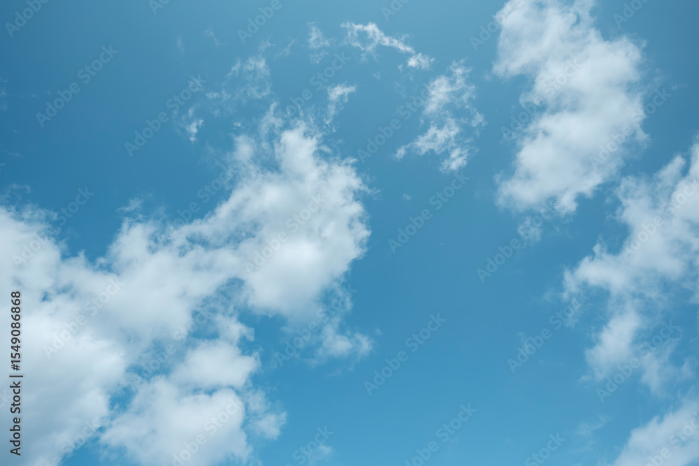 Fototapeta premium ふわふわした薄い雲と夏のようなさわやかな青空 風に流れる雲と美しい天気 